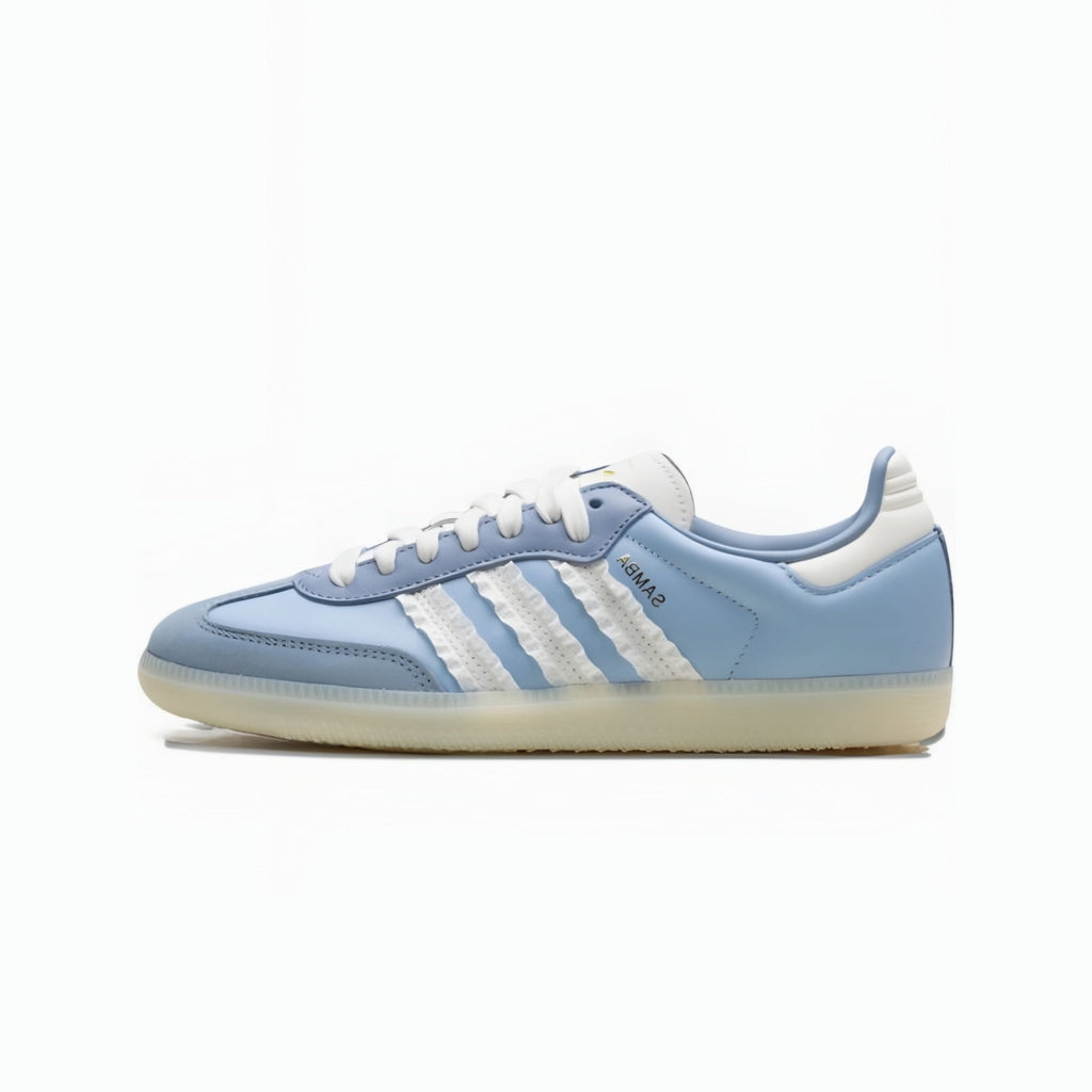 A light blue Adidas Samba sneaker with white three-stripes, white laces, and a white heel tab, set against a plain white background.