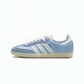A light blue Adidas Samba sneaker with white three-stripes, white laces, and a white heel tab, set against a plain white background.