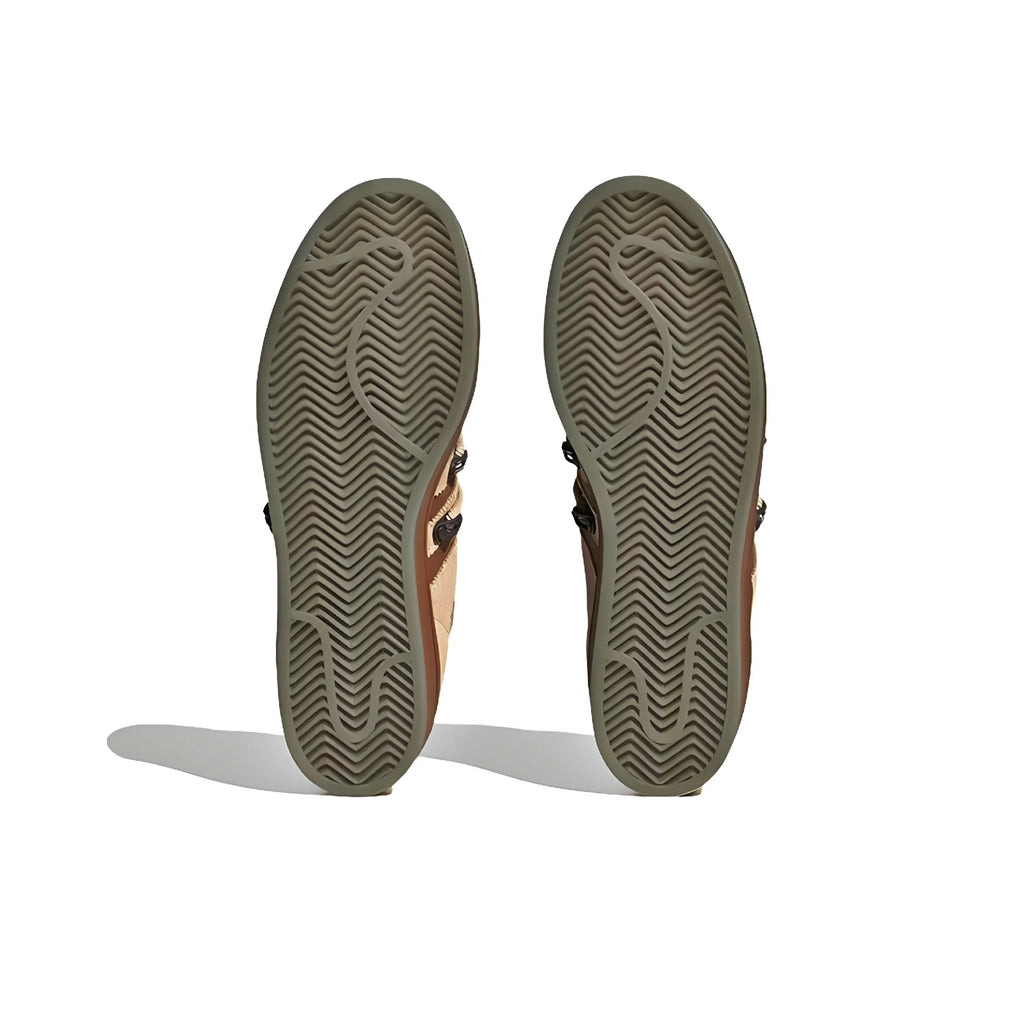 The soles of adidas superstar melting sadness shoes, shown from the bottom against a white background.