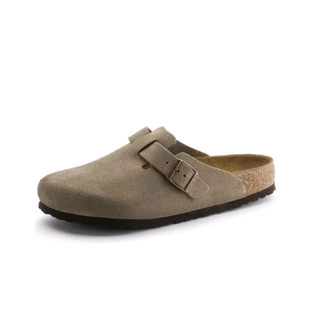 A single taupe suede clog shoe with a brown buckle strap and a cork-look midsole, shown from a side profile on a white background.