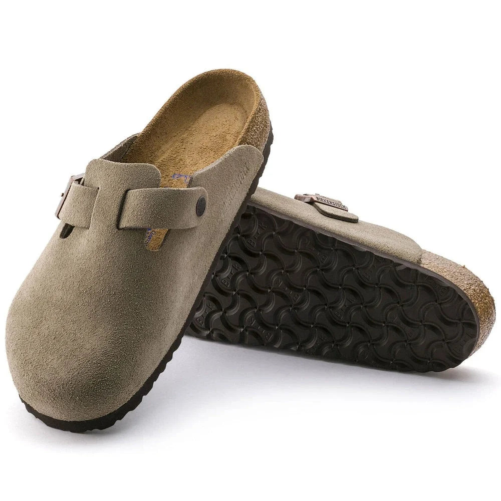 Pair of brown suede clogs with black soles on a white background