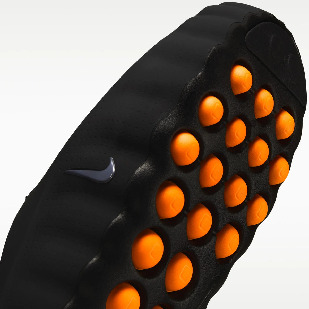 Black shoe sole with orange and Nike logo on a white background