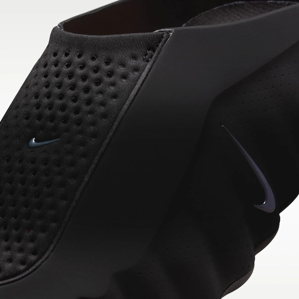 Close-up of a black Nike slip-on shoe with perforated side panels, a sculpted black sole, and a subtle dark gray Nike Swoosh logo.