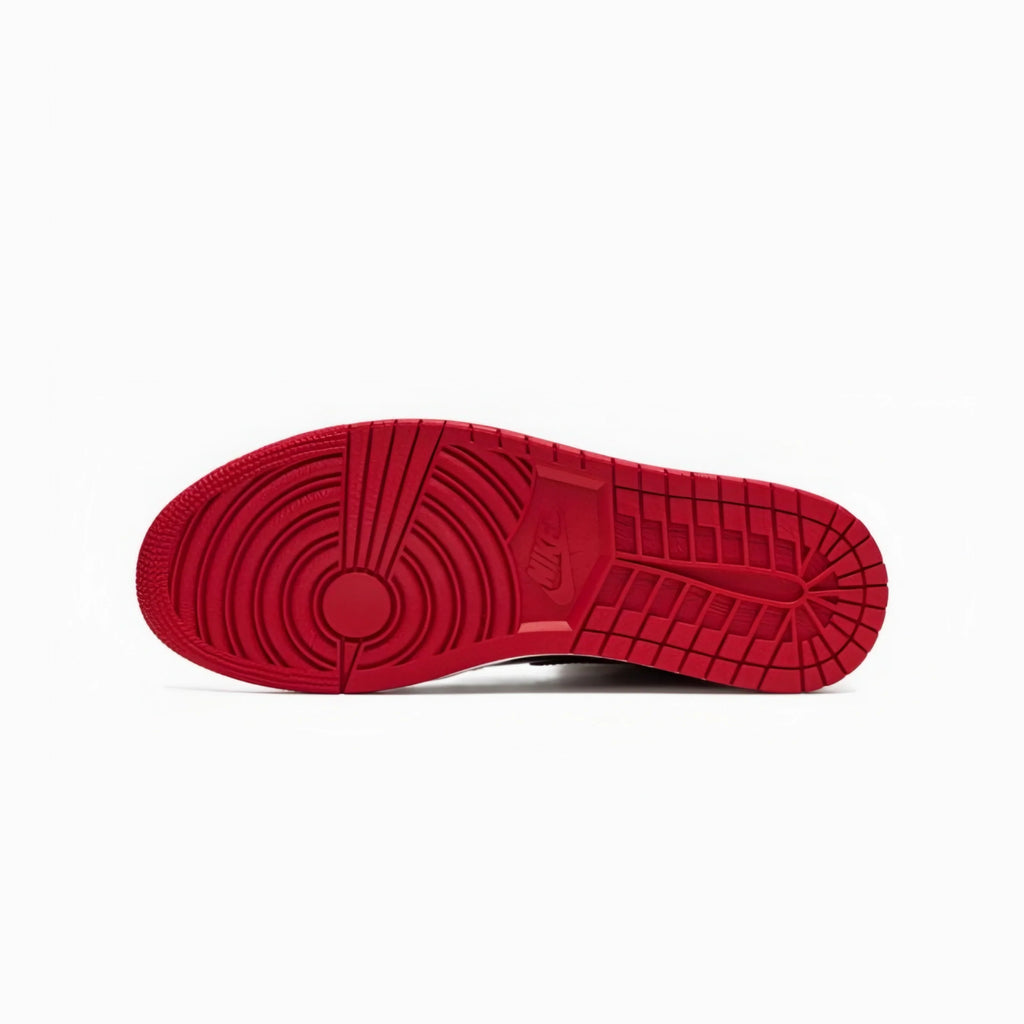 The red outsole of a Nike sneaker, showing the textured tread pattern and embossed Nike logo, photographed from a top-down view on a white background.