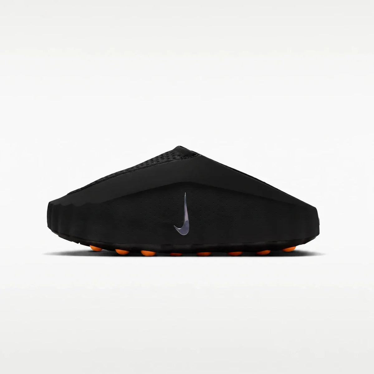 A black Nike slip-on shoe with a textured upper, a dark gray Swoosh logo on the side, and bright orange outsole details, shown against a clean white background.