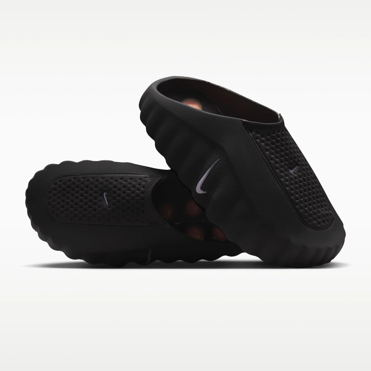 Black Nike mind sandals on a white background