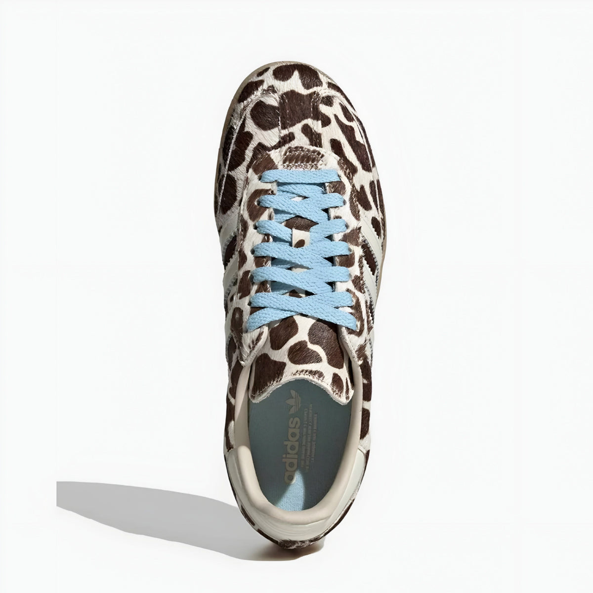 Giraffe print samba sneaker with blue laces on a white background
