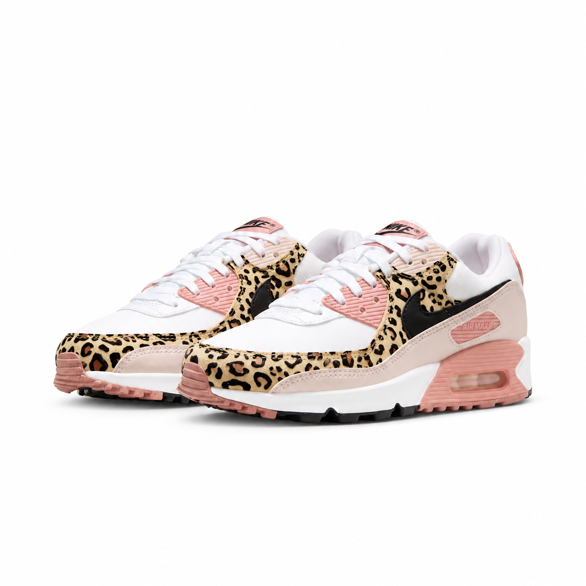 A pair of Nike Air Max 90 sneakers featuring a leopard print pattern on the overlays, white leather panels, pink laces and midsole cushioning, and a black Swoosh logo.